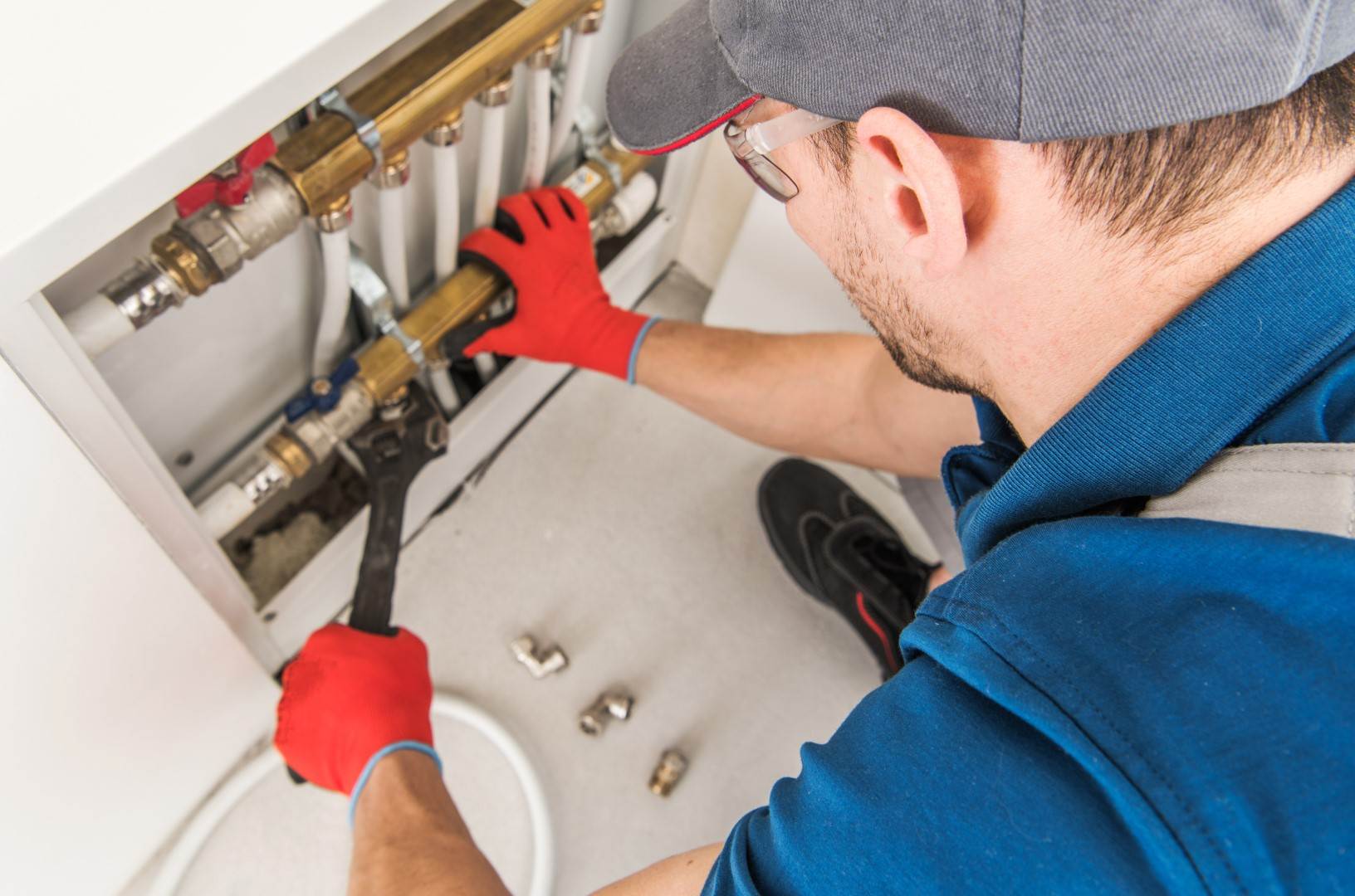 A Victor Plumbing plumber working on a water heater.